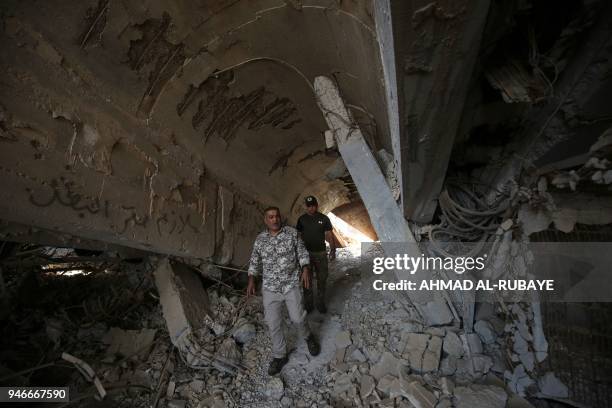 Iraqi fighters from the Hashed al-Shaabi check the severely damaged tomb of the late Iraqi dictator Saddam Hussein in the village of Al-Awja, on the...