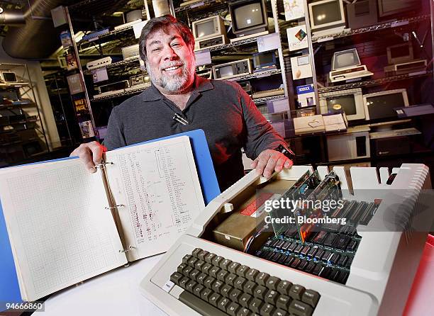 Steve Wozniak, co-founder of Apple Inc., displays a 150-page notebook with his handwritten code for the Apple II computer, foreground, at the...