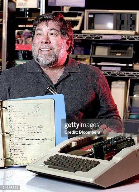 Steve Wozniak, co-founder of Apple Inc., displays a 150-page notebook with his handwritten code for the Apple II computer, foreground, at the...