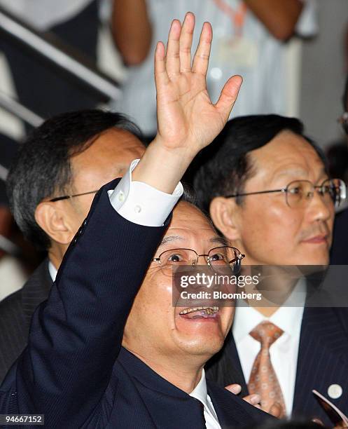 Wen Jiabao, China's premier, waves to the audience gathered to hear his speech at the National University of Singapore, in Singapore, on Monday, Nov....