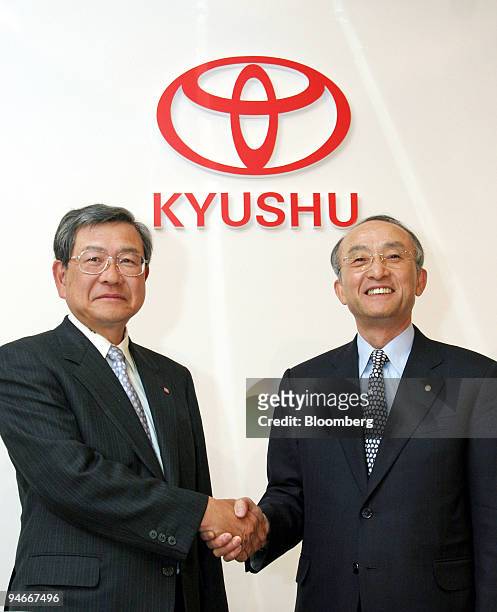 Toyota Motor Corp. President Katsuaki Watanabe, right, shakes hands with Toyota Motor Kyushu Inc. President Akiyoshi Watanabe, left, under the...