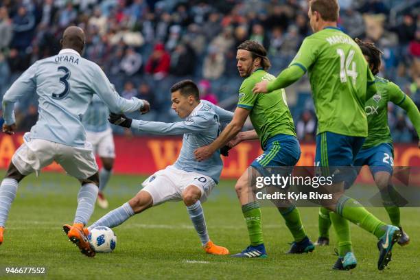 Daniel Salloi of Sporting Kansas City attempt to work around Gustav Svensson of Seattle Sounders during the second half on April 15, 2018 at...