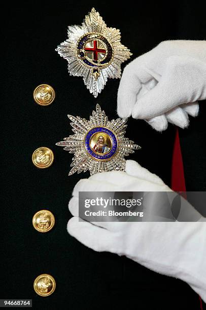 Member of staff at Buckingham Palace alters the medals on the uniform worn by Prince Philip during his marriage ceremony to Queen Elizabeth II on...