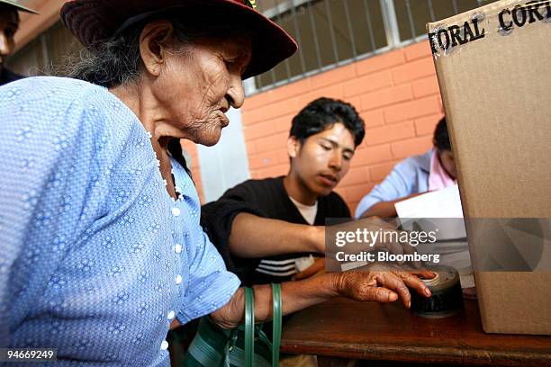 An elderly Quechua farmer marks her pinky finger with ink after casting her ballot in Bolivia's autonomy referendum and elections for the nation's...