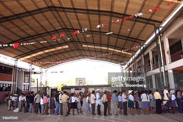 Quechua farmers wait in line to vote in Bolivia's autonomy referendum and elections for the nation's upcoming constituent assembly, in the Chapare...