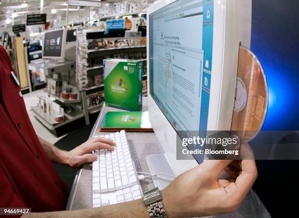 David Mason, assistant sales manager at a CompUSA store in Orem, Utah, prepares to install Windows XP software on an Apple Intel iMac computer on...