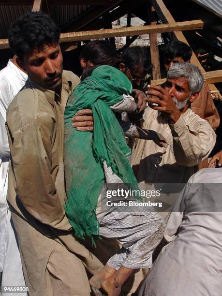Volunteers recover the bodies of students from the wreckage of a school Sunday, October 9, 2005 in the town of Balakot in northern Pakistan. The...