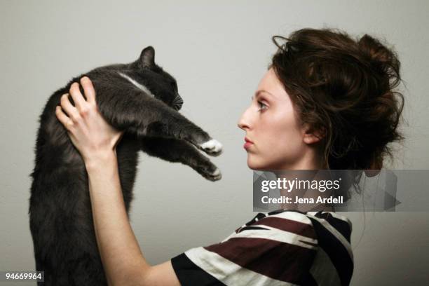 profile of woman w/ messy hair holding gray cat - angry cat stock pictures, royalty-free photos & images