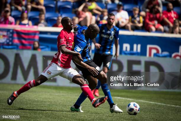 Bradley Wright-Phillips of New York Red Bulls fights for control of the ball against Rod Fanni of Montreal Impact during the Major League Soccer...
