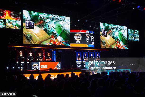 Spectators watch as digital monitors display photos of team Splyce, left, and Tox, during the Halo World Championship finals in Seattle, Washington,...