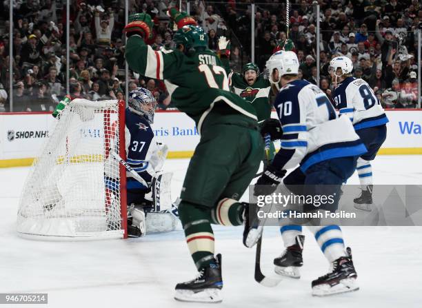 Eric Staal and Jason Zucker of the Minnesota Wild celebrate a goal by Staal as Connor Hellebuyck, Joe Morrow and Kyle Connor of the Winnipeg Jets...