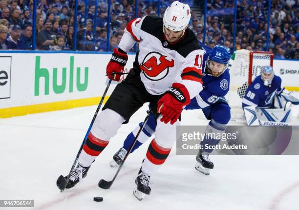 Braydon Coburn of the Tampa Bay Lightning skates against Brian Boyle of the New Jersey Devils in Game Two of the Eastern Conference First Round...