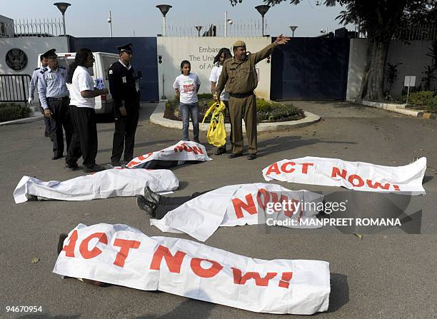 An Indian policeman gestures as he attempts to prevent Greenpeace activists from staging a protest outside the US embassy in New Delhi on December 17...
