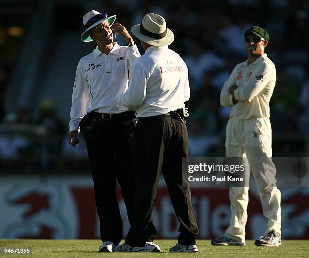 Umpires Billy Bowden and Ian Gould discuss a decision from the third umpire as Michael Hussey of Australia looks on during day two of the Third Test...
