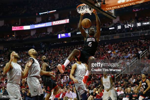 Clint Capela of the Houston Rockets dunks the ball against Derrick Rose of the Minnesota Timberwolves and Karl-Anthony Towns in the first half during...