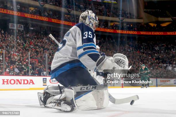 Steve Mason of the Winnipeg Jets covers the puck against the Minnesota Wild in Game Three of the Western Conference First Round during the 2018 NHL...