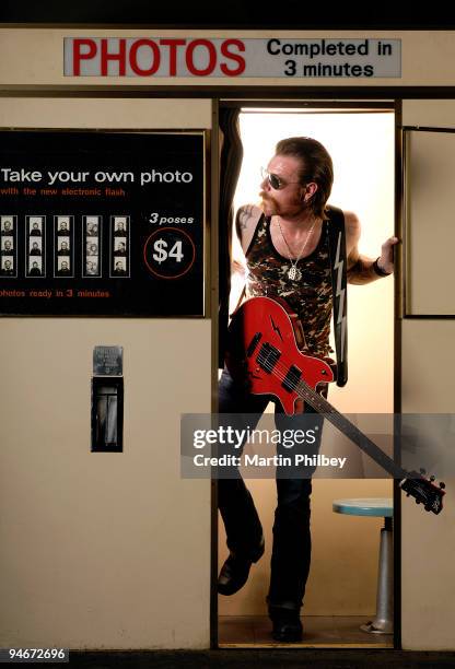 Jesse 'The Devil' Hughes of Eagles of Death Metal poses for a portrait session in a photo booth, holding a Maton guitar, on March 16th 2007 in...