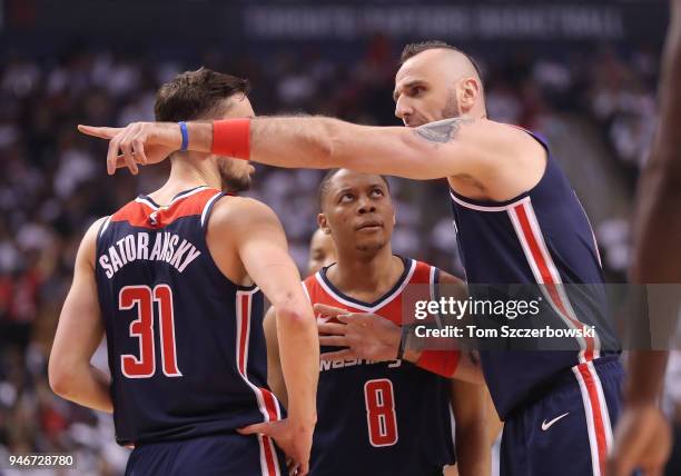 Marcin Gortat of the Washington Wizards talks to Tomas Satoransky and Tim Frazier against the Toronto Raptors in the first quarter during Game One of...