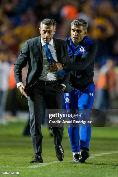 Elias Domingos tries to calm down Pedro Caixinha, coach of Cruz Azul, after he was expeled from the field during the 15th round match between Tigres...