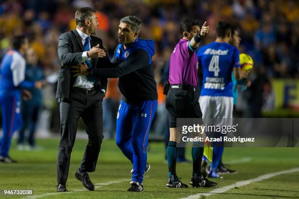 Elias Domingos tries to calm down Pedro Caixinha, coach of Cruz Azul, after he was expeled from the field during the 15th round match between Tigres...