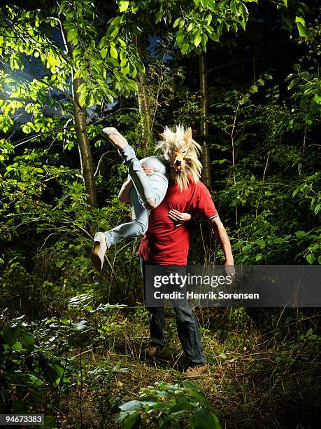 wolf man with female victim over shoulder - erwachsene imitieren stock-fotos und bilder