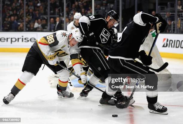 Tanner Pearson and Adrian Kempe of the Los Angeles Kings battle Nate Schmidt of the Vegas Golden Knights for a loose puck during the second period in...