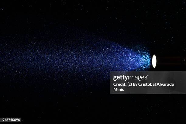 flashlight switched on, isolated on blue - lampe de poche photos et images de collection