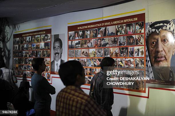 Indian visitors look at a 'Anti-imperialism movement in the world' photo exhibition organised by the Forward Block party in Kolkata on December 17,...