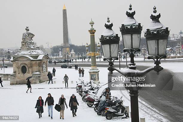 People walk in the snow in the Place De La Concorde on December 17, 2009 in Paris, France. Berlin, London and Paris have all recorded temperatures...
