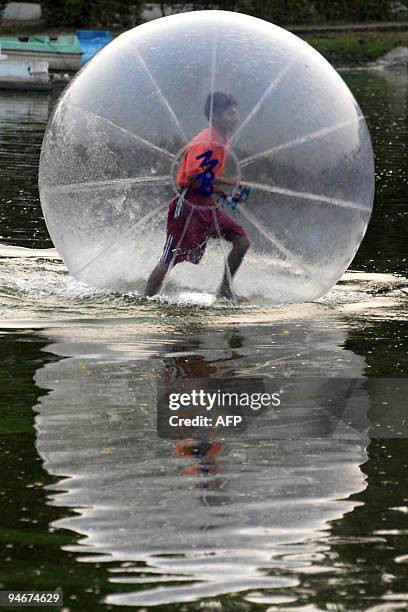 Youth, contained inside a "water walking ball", makes his way over a lake at Dighalipukhuri in Guwahati, the capital city of India�s northeastern...