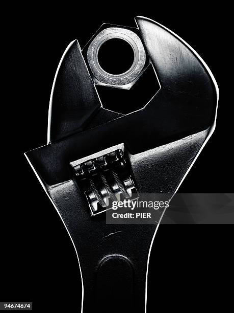 adjustable wrench holding a large steel nut - nut fastener stock-fotos und bilder