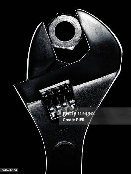 adjustable wrench holding a large steel nut - steel pier stock pictures, royalty-free photos & images