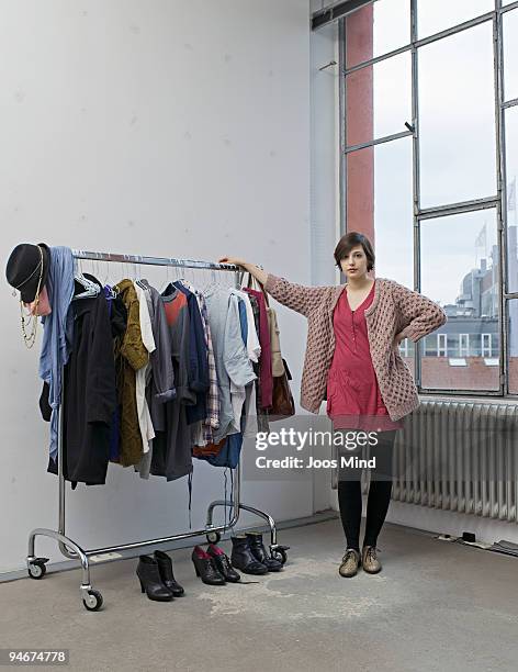 young woman and her clothes, portrait - clothes rack fotografías e imágenes de stock