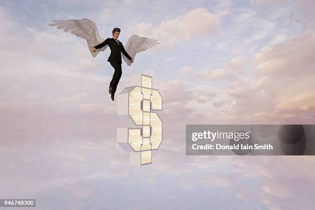 angel investor: man with angel wings hovering with lit up dollar sign - angel investor stock-fotos und bilder