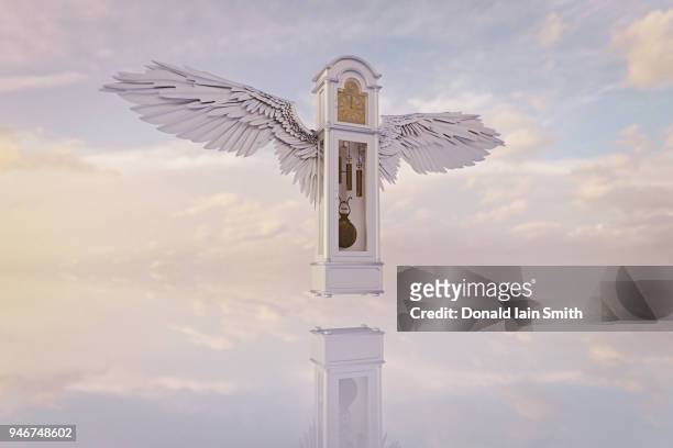 time flies: grandfather clock with wings flying over reflecting surface with clouds - タイムトラベル ストックフォトと画像