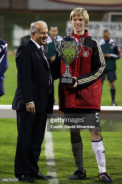 Pelle Jensen , captain of the German Under-18 squad, receives the winners trophy from Israeli Football Association chairman Avi Luzon on December 17,...