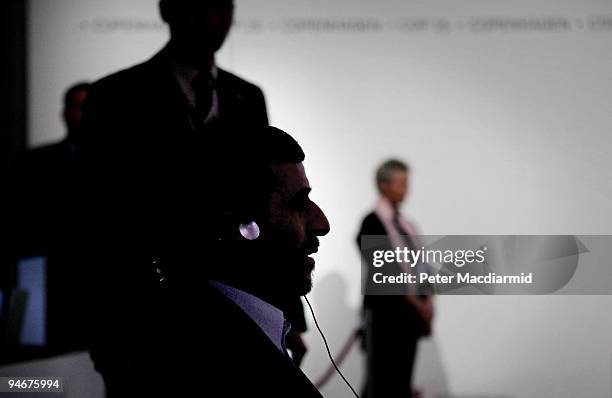 Iranian President Mahmoud Ahmadinejad sits in the shadows as he waits to address delegates at the UN Climate Change Conference on December 17, 2009...