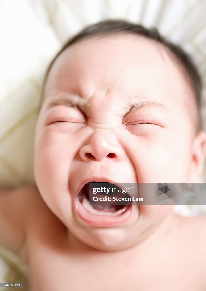 Baby crying with eyes closed