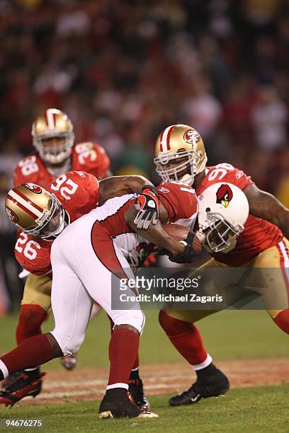 Mark Roman of the San Francisco 49ers tackles Anquan Boldin of the Arizona Cardinals during the NFL game at Candlestick Park on December 14, 2009 in...