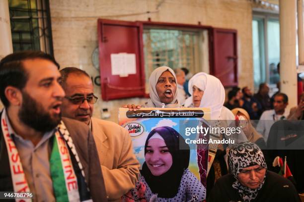 Woman holds a poster of a prisoner during a demonstration in support of the Palestinian prisoners in Israeli jails, in front of International...