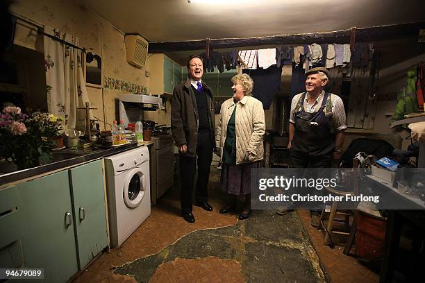 Conservative party leader David Cameron chats to Cockermouth residents Jim and Eileen Lawson inside their water damaged home on December 17, 2009 in...