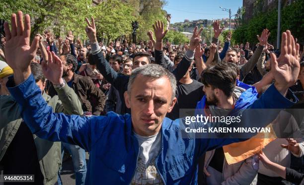 People raise their hands during an opposition rally in central Yerevan on April 16, 2018. Around a thousand protesters staged rallies on April 16,...