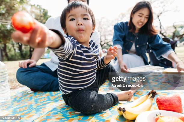 彼の食糧を共有する子 - family at a picnic ストックフォトと画像