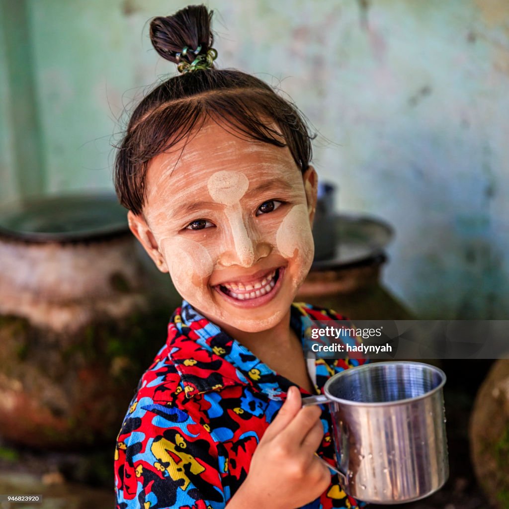 Kleine Birmaanse meisje drinkwater in dorp in de buurt van Bagan, Myanmar