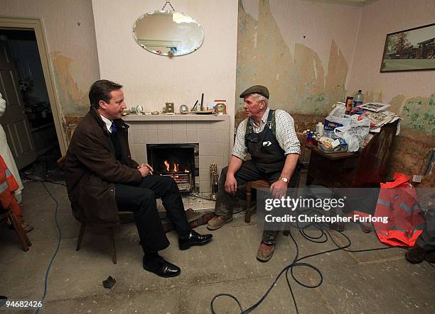 Conservative party leader David Cameron chats to Cockermouth resident and businessman Jim Lawson inside his water damaged home on December 17, 2009...