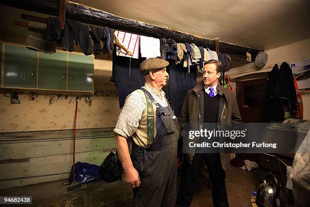 Conservative party leader David Cameron chats to Cockermouth resident and businessman Jim Lawson inside his water damaged home on December 17, 2009...