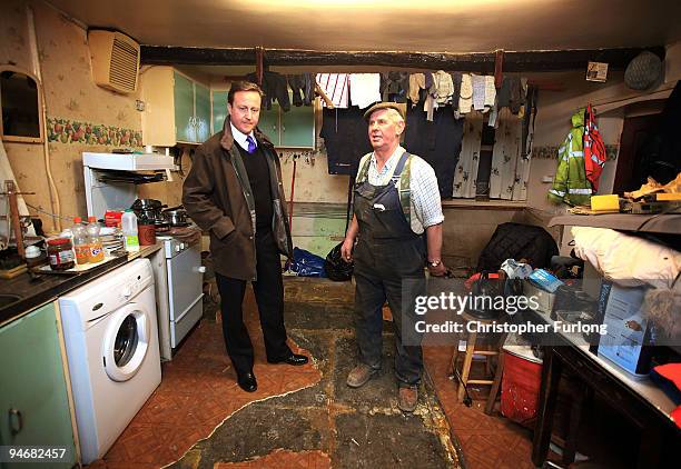 Conservative party leader David Cameron chats to Cockermouth resident and businessman Jim Lawson inside his water damaged home on December 17, 2009...