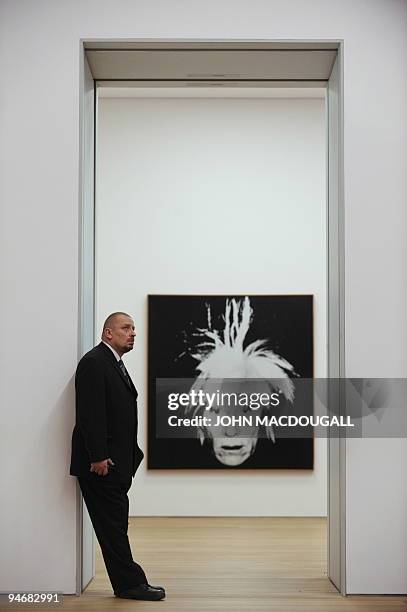 Museum guard stands next to a self-portrait by US artist Andy Warhol at the Brandhorst museum in Munich December 15, 2009. The Brandhorst Museum was...