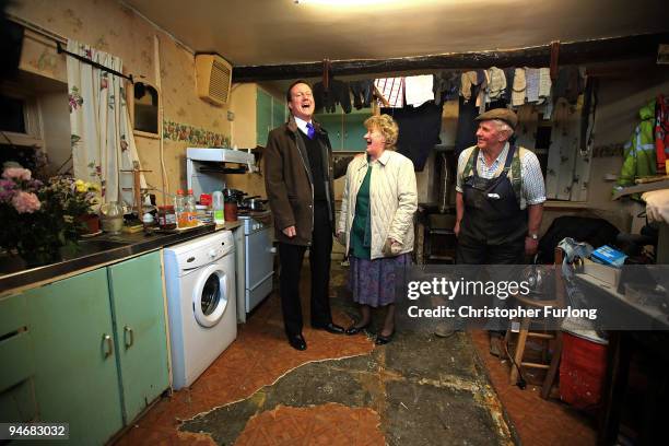 Conservative party leader David Cameron shares a joke with Cockermouth resident and businessman Jim Lawson and his wife Eileen inside their water...