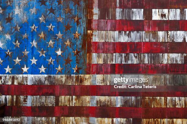 decaying american flag painted on a rusty door - decadente foto e immagini stock